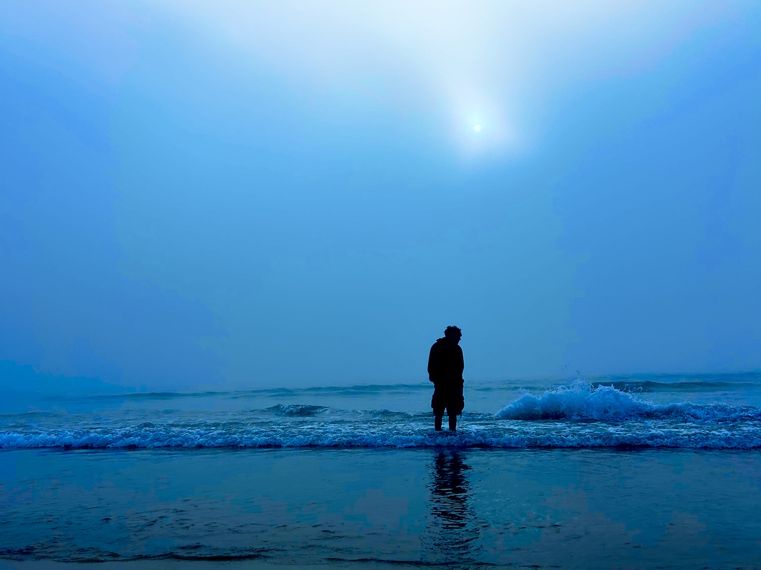 Abhigya silhouette standing in ocean waves